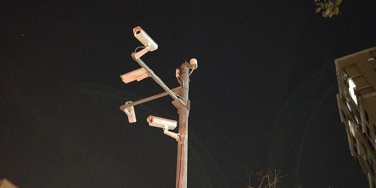 Several CCTV cameras mounted on a street pole in Mumbai.