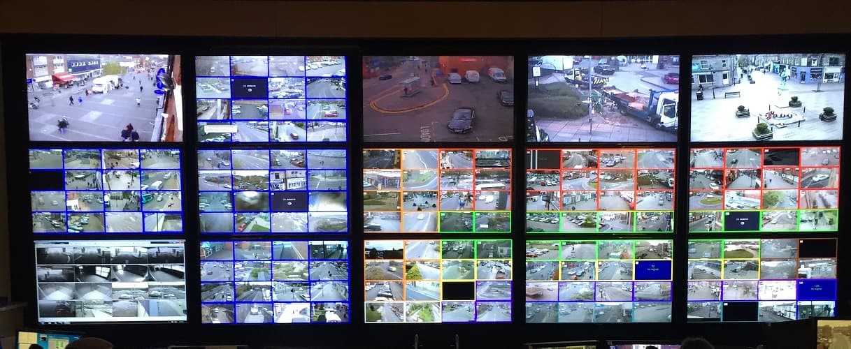 A wall of surveillance monitors showing multiple camera feeds.